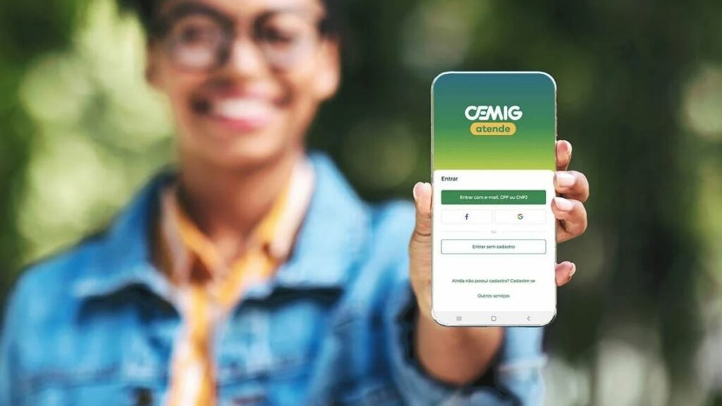 WhatsApp Cemig: Telefones, Chat, SAC 0800, Ouvidoria e demais formas de atendimento 2 App Cemig. Mulher segurando o celular com o app aberto