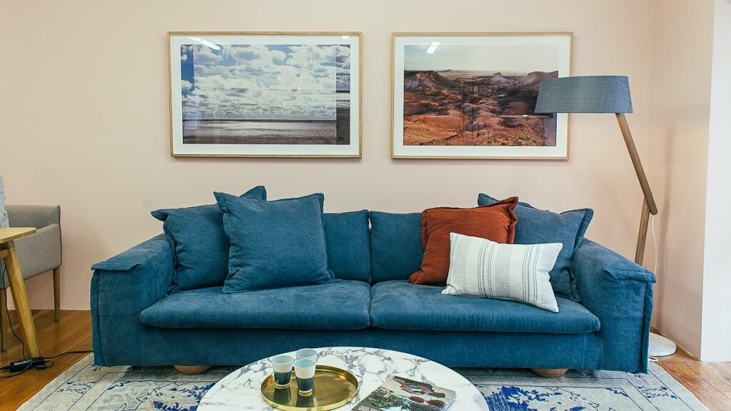 Modelos de sofá: como escolher o ideal para sua sala 1 Modelos de sofá azul em uma sala com quadros na parede