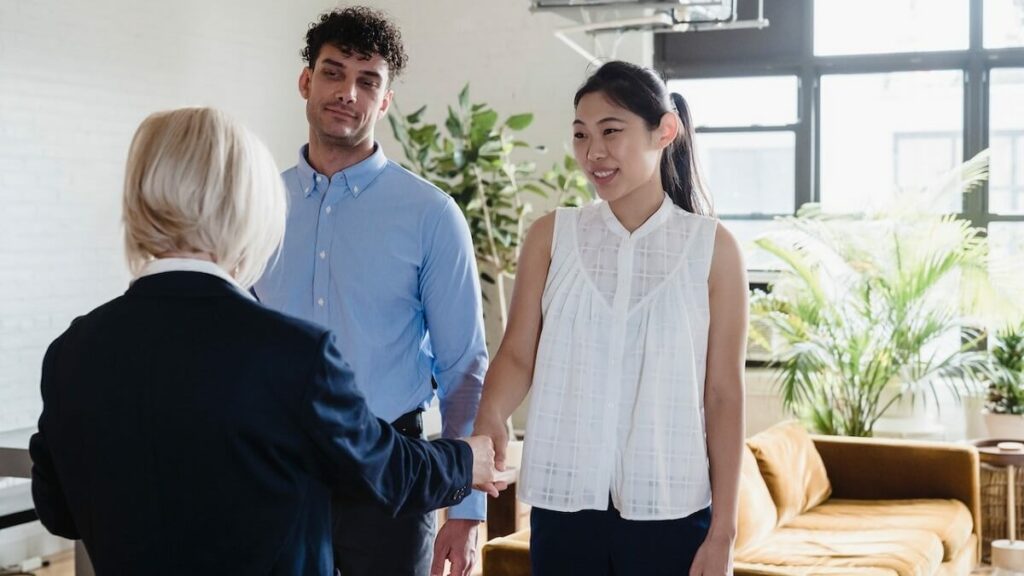 Casal fechando negócios com corretora de imóveis