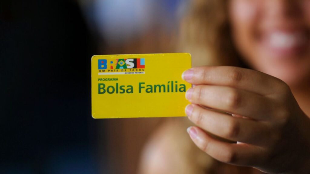 Mulher com cartão Bolsa Família