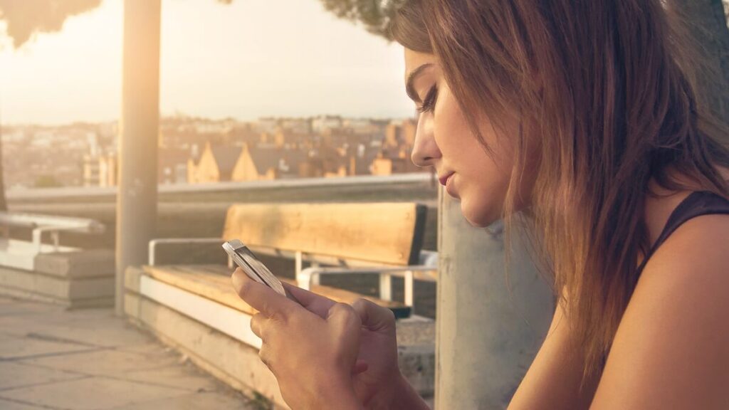 O que significa crt no WhatsApp? Confira aqui como usar essa abreviação! 2 Mulher usando o celular