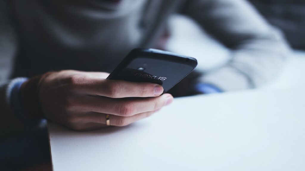 A imagem condiz a um homem utilizando o celular.
