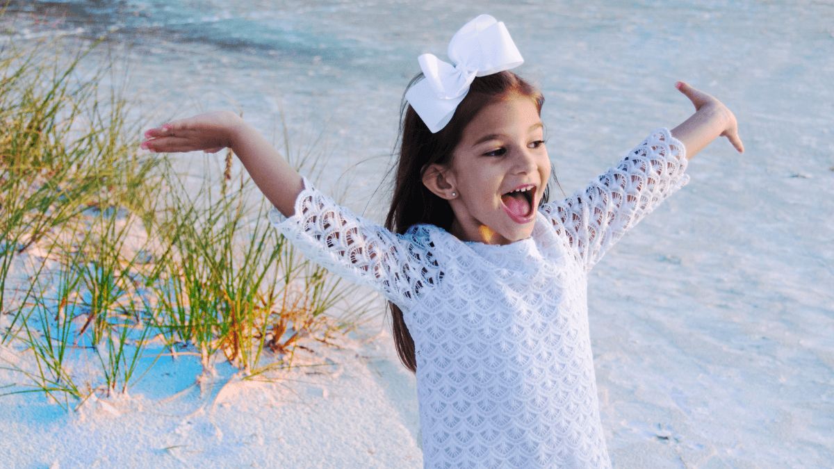 Nomes femininos com J, + de 330 opções para inspirar! 4 Menina feliz com laço branco no cabelo