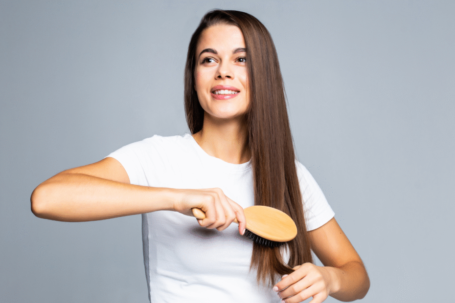 Segredos para deixar os cabelos sempre bem cuidados 3 Mulher morena deixando os cabelos sempre cuidados com um fundo branco.