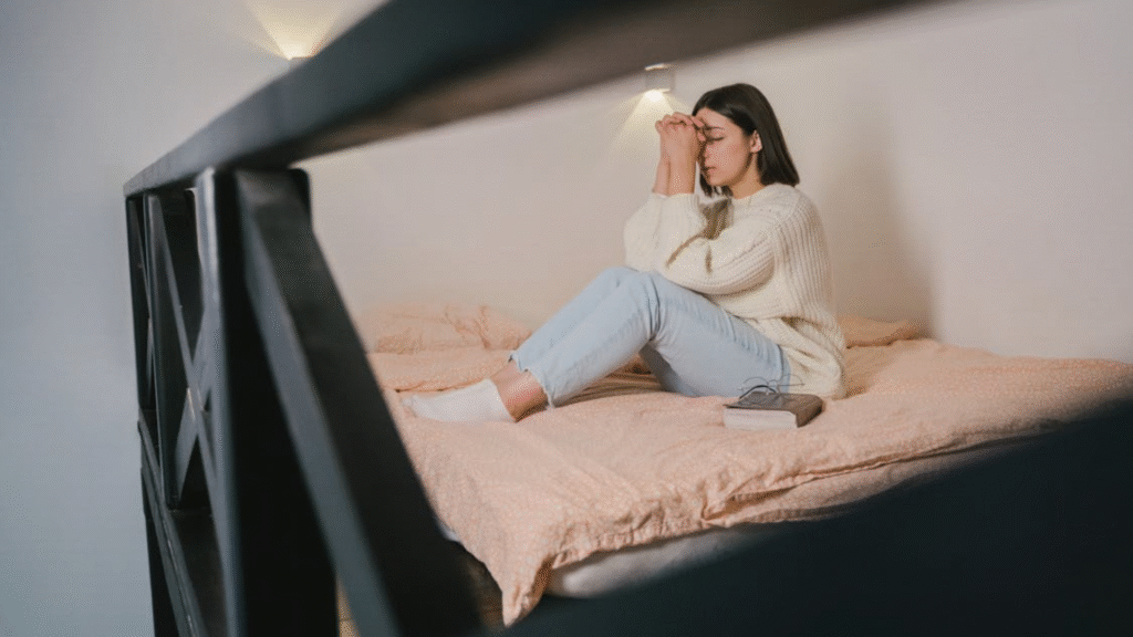 Exame de Consciência para Confissão: O Que É e Como Fazer 1 Mulher fazendo um exame de Consciência para Confissão em cima da sua cama.