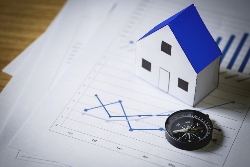 Expectativas para o mercado imobiliário em 2026 1 Uma casa em cima de uns papeis.